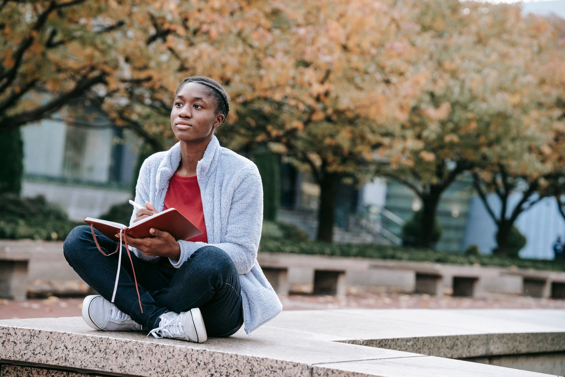 A BIPOC woman sitting in quiet, grounded reflection, the weight and clarity of breaking a family pattern
